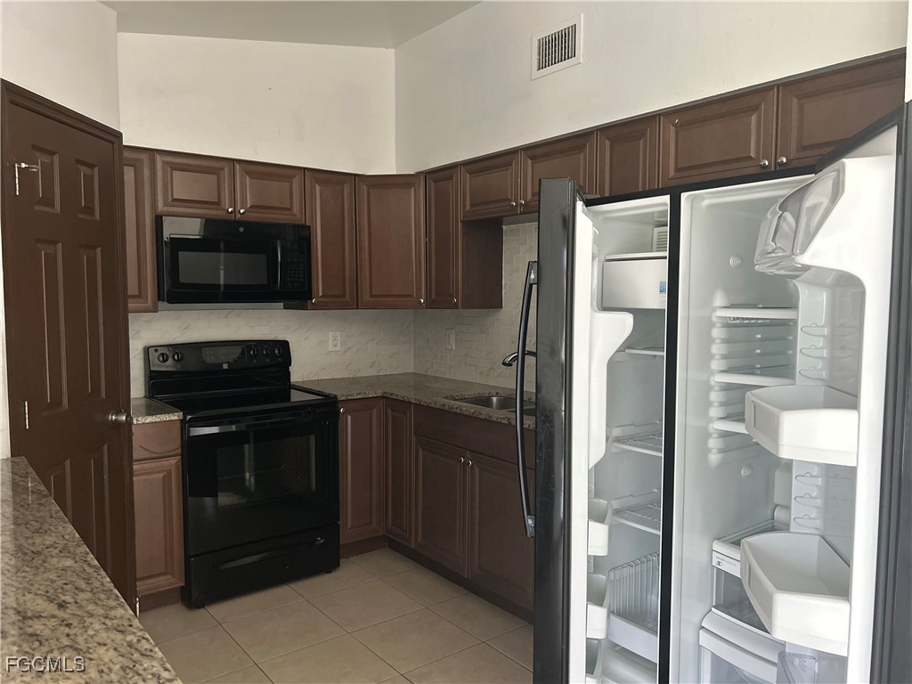 729 Southwest 46th Street Cape Coral, FL 33914 - Photo 8 of 20 a kitchen with a refrigerator and a sink