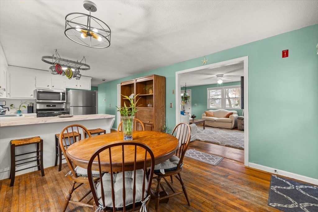 281 Megan Road Barnstable, MA 02601 - Photo 15 of 36 a dining room with wooden floor a chandelier a wooden table and chairs
