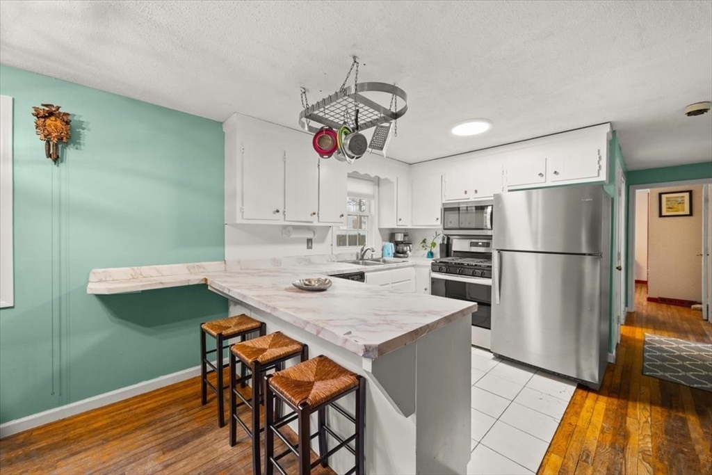 281 Megan Road Barnstable, MA 02601 - Photo 9 of 36 a kitchen with stainless steel appliances granite countertop a refrigerator a sink dishwasher a stove and a refrigerator with wooden floor