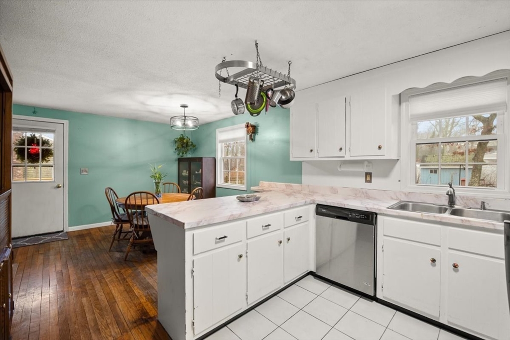 281 Megan Road Barnstable, MA 02601 - Photo 10 of 36 a kitchen with a sink dishwasher and white cabinets with wooden floor