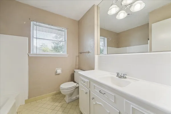 a bathroom with a sink a toilet and a mirror
