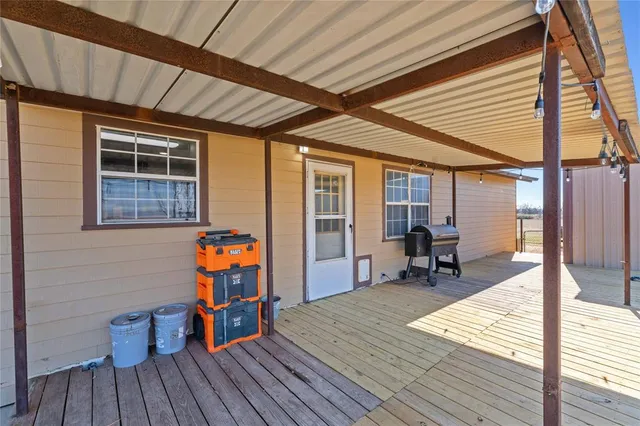 a deck of a house with wooden floor and outdoor seating