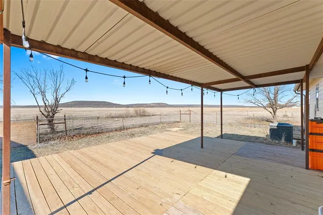 a backyard of a house with wooden floor and outdoor seating