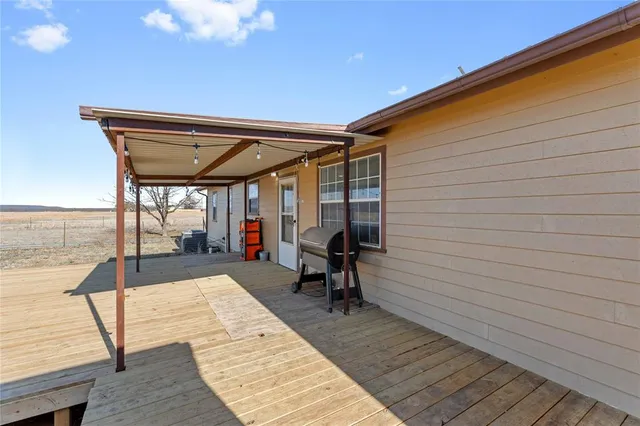 a view of a balcony with chairs and wooden floor