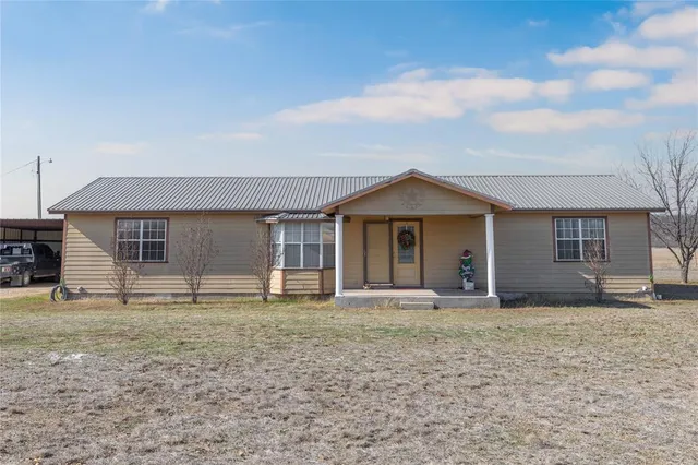 a view of a house with backyard and porch