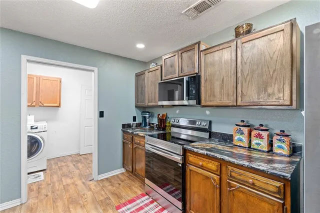 a kitchen with stainless steel appliances granite countertop a sink stove and microwave