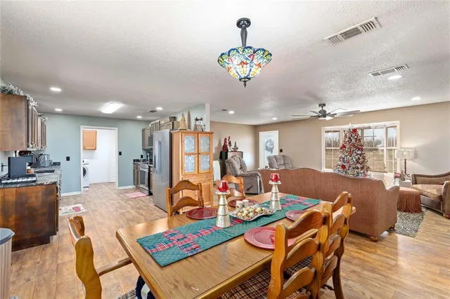 a view of a dining room with furniture a chandelier and wooden floor