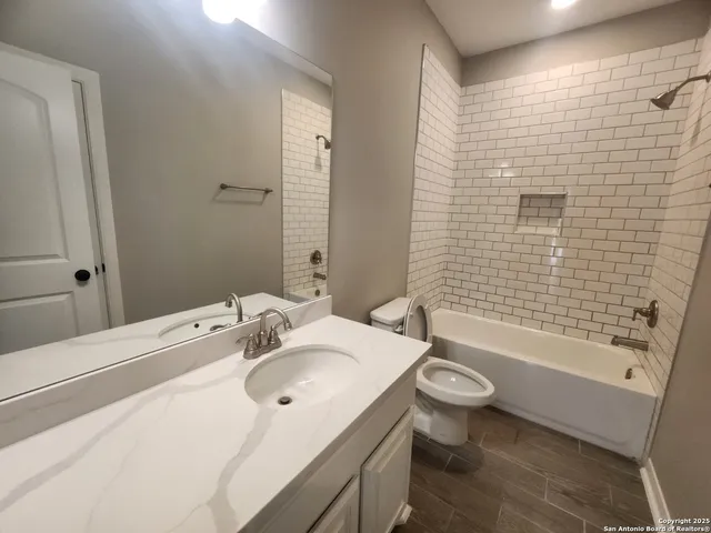 an empty room with wooden floor and a ceiling fan