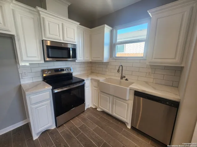 a kitchen with stainless steel appliances granite countertop a sink stove and microwave