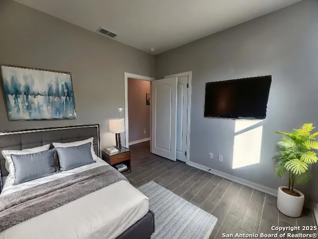 a bedroom with furniture and a flat screen tv