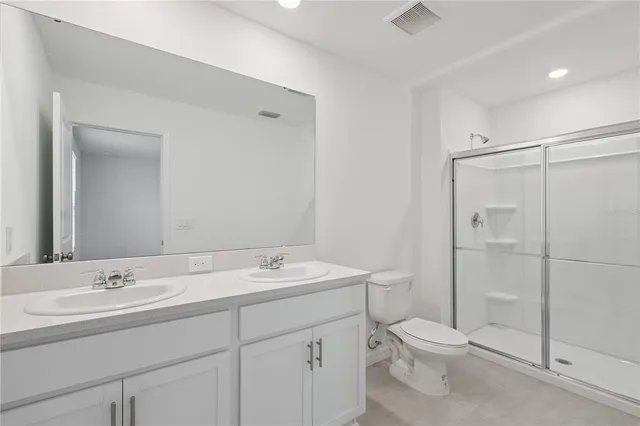 a bathroom with a toilet a sink a mirror and vanity