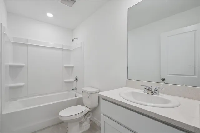 a bathroom with a sink a toilet and a large mirror