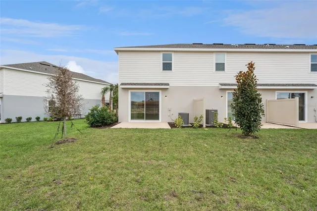 a view of a house with a yard and a tree