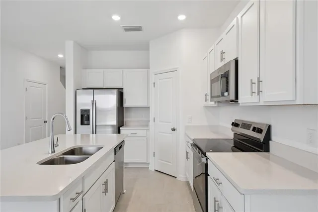 a kitchen that has a sink and a stove top oven