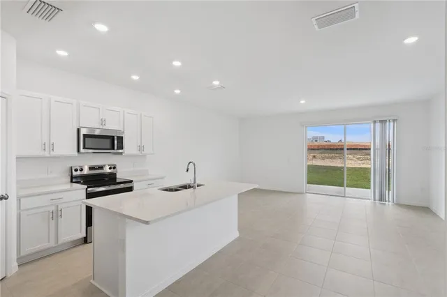 a kitchen with a sink a counter top space cabinets and stainless steel appliances