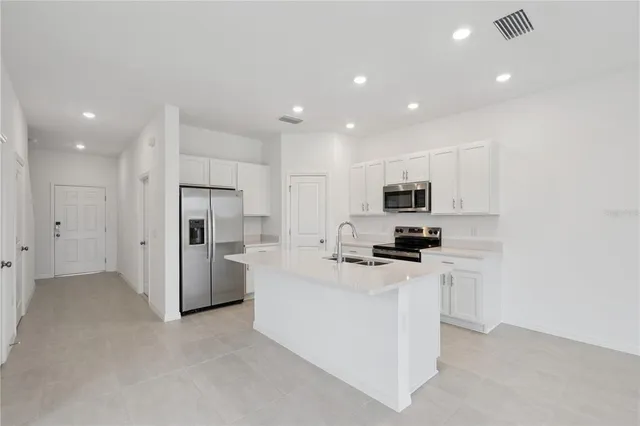 a kitchen with white cabinets and stainless steel appliances