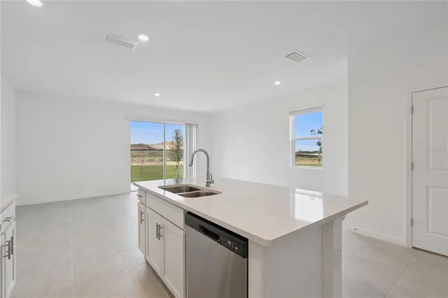 a kitchen with stainless steel appliances granite countertop a sink and a refrigerator