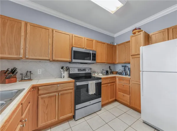 a kitchen with stainless steel appliances granite countertop a refrigerator stove a sink dishwasher and microwave with cabinets