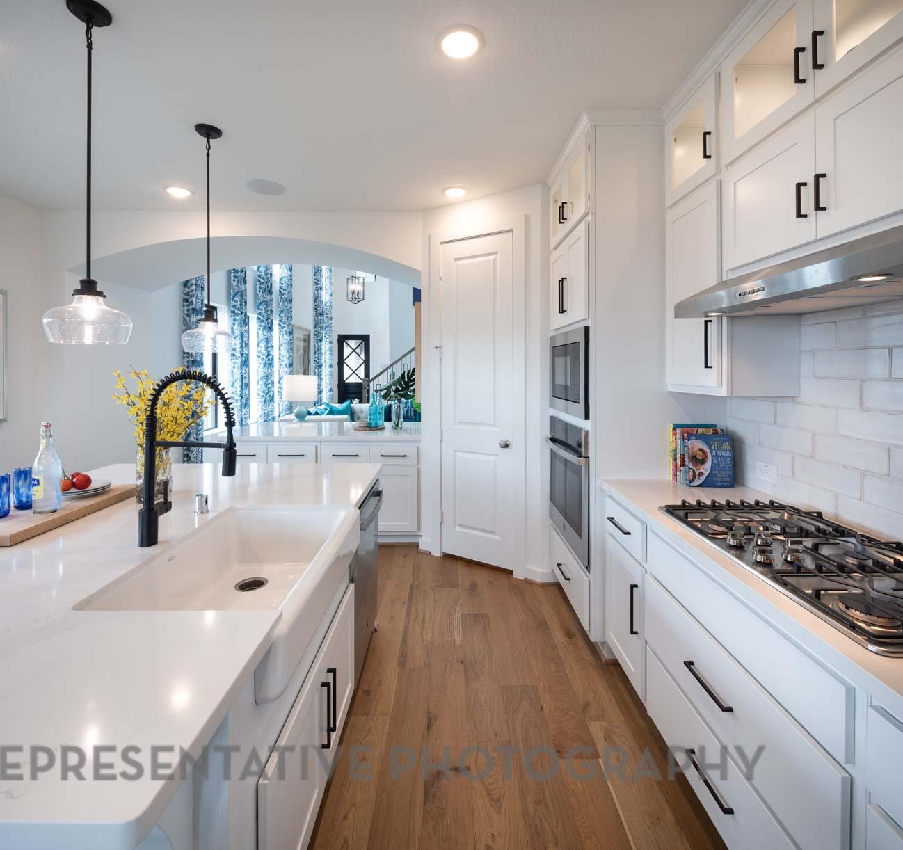 2426 Guava Hls Lane Manvel, TX 77578 - Photo 7 of 48 a kitchen with stainless steel appliances kitchen island a refrigerator and a sink