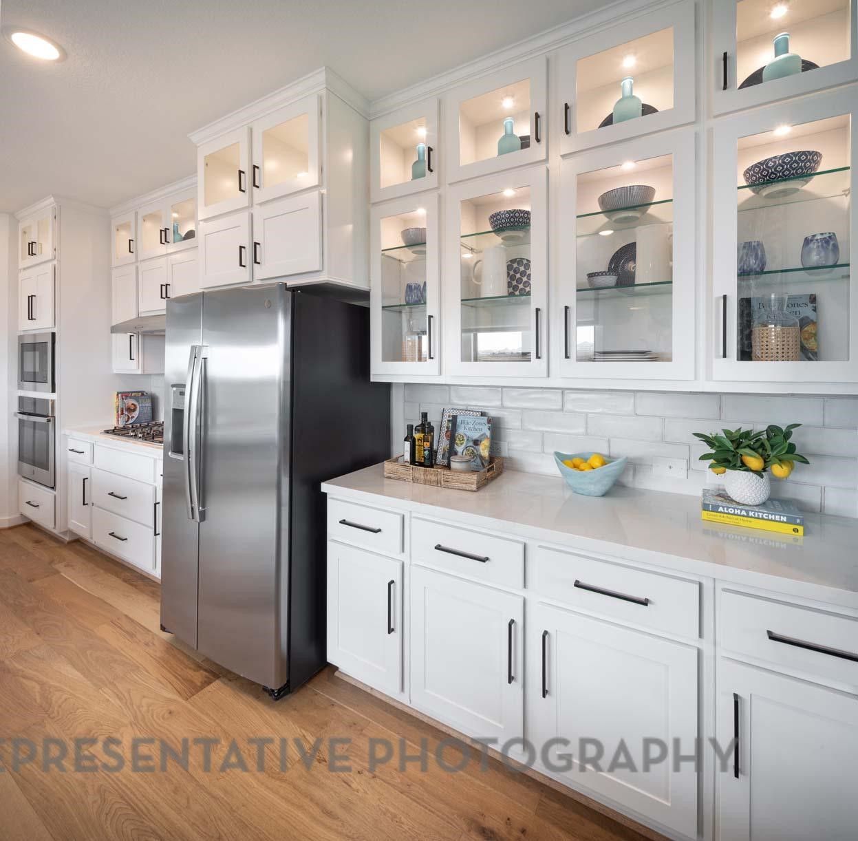 2426 Guava Hls Lane Manvel, TX 77578 - Photo 8 of 48 a kitchen with stainless steel appliances a refrigerator a sink and white cabinets