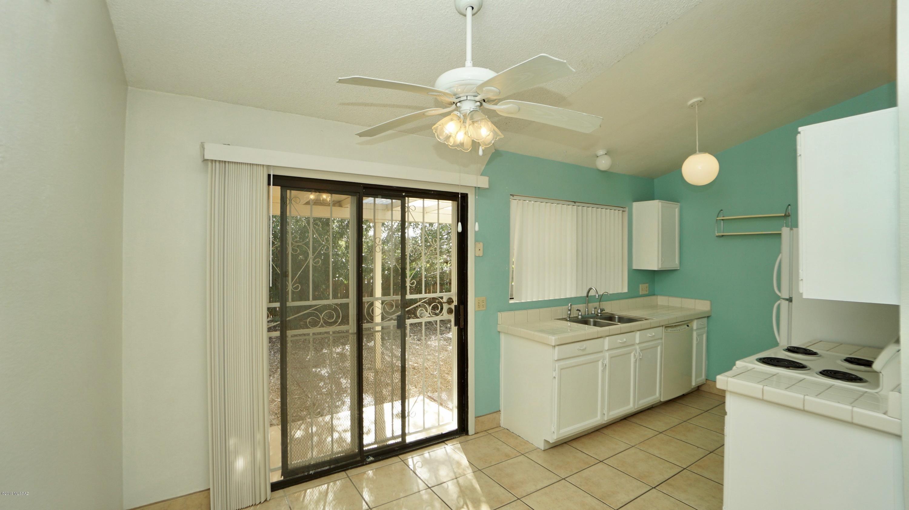 4796 South Lincoln Ridge Drive Tucson, AZ 85730 - Photo 5 of 12 a kitchen with a stove a sink and a refrigerator