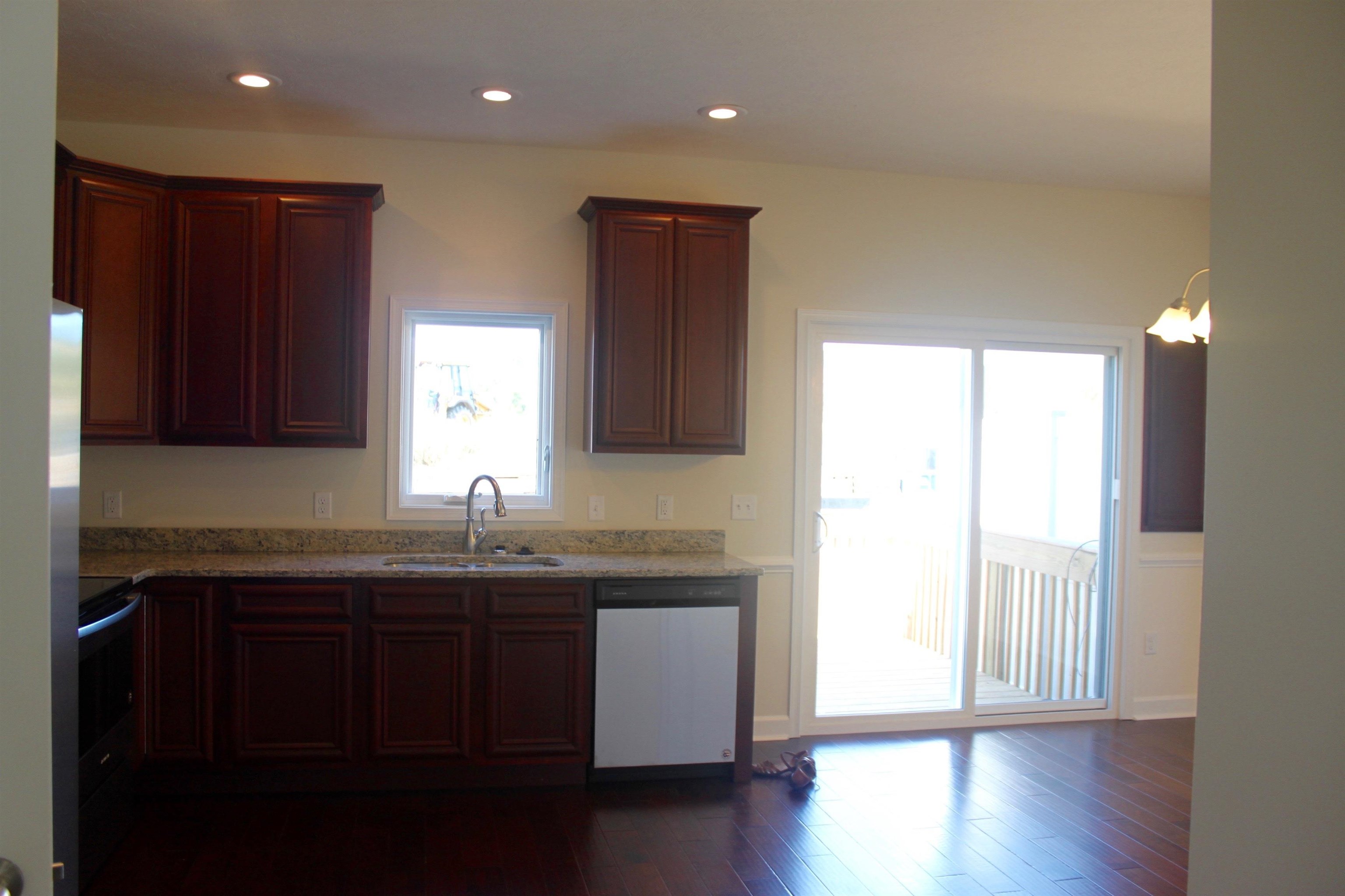 113 Cedar Point Lane Harrisonburg, VA 22802 - Photo 5 of 25 a kitchen with stainless steel appliances granite countertop wooden cabinets a sink and dishwasher with wooden floor