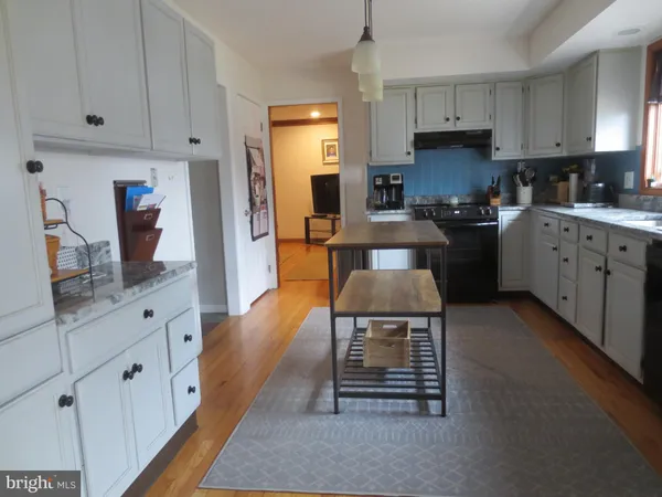 a kitchen with granite countertop a sink stove and cabinets