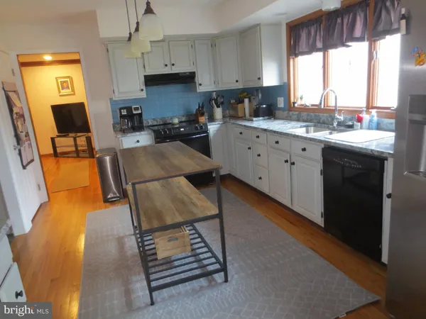 a kitchen with a sink appliances cabinets and a window