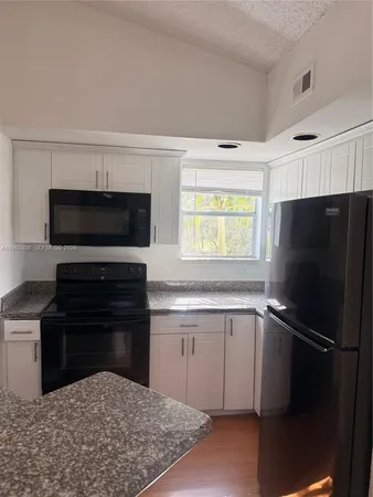 a kitchen with a refrigerator stove and microwave