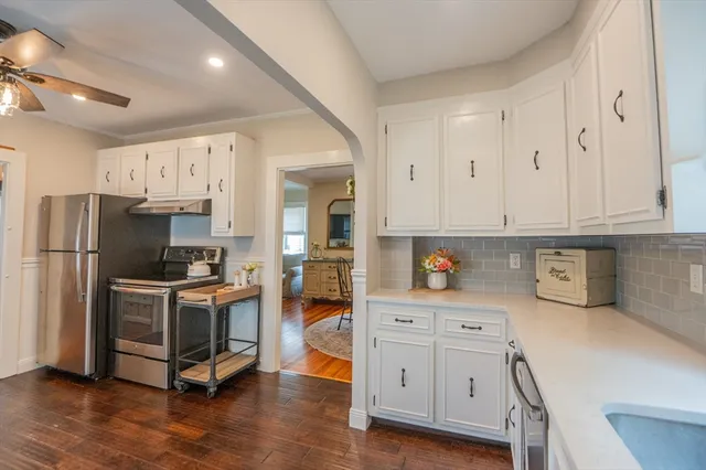 a kitchen with white cabinets and stainless steel appliances