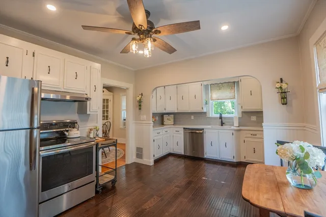 a kitchen with a refrigerator and white cabinets