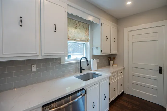 a kitchen with cabinets appliances a sink and a window