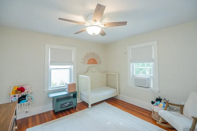 a bedroom with baby bed toys and paintings on the wall