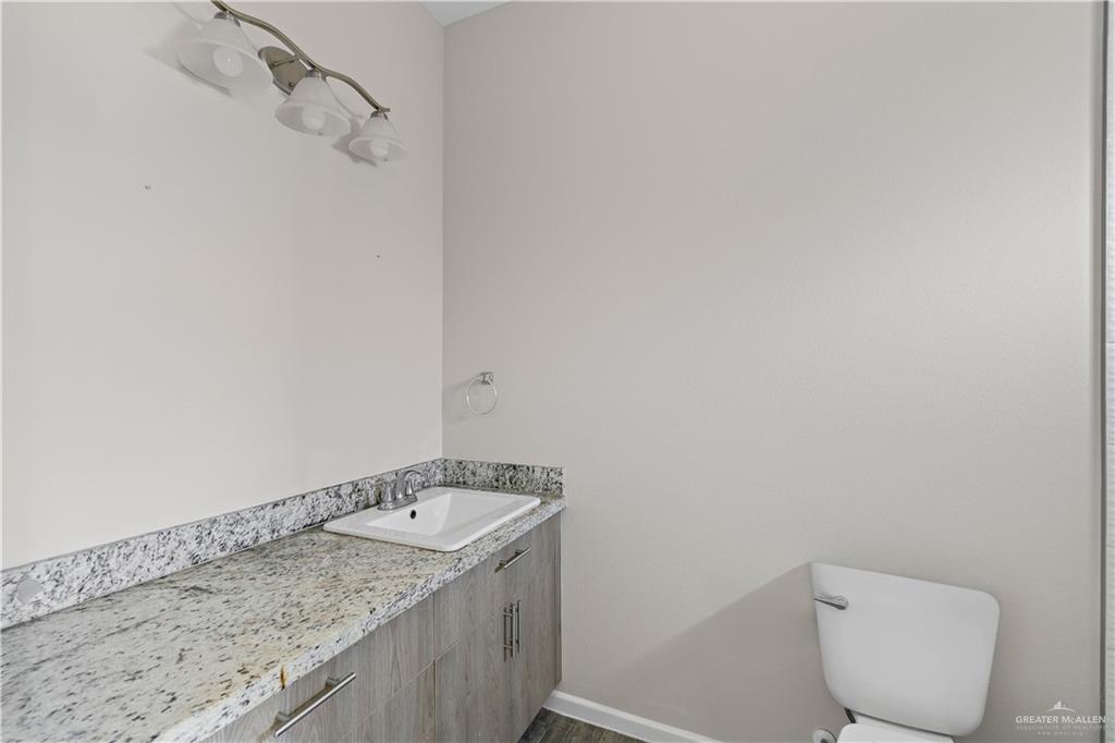 912-3 Kentucky Street Alton, TX 78573 - Photo 11 of 17 a bathroom with a granite countertop toilet and a sink