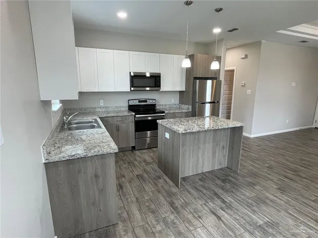 a kitchen with stainless steel appliances granite countertop a stove a sink and a refrigerator