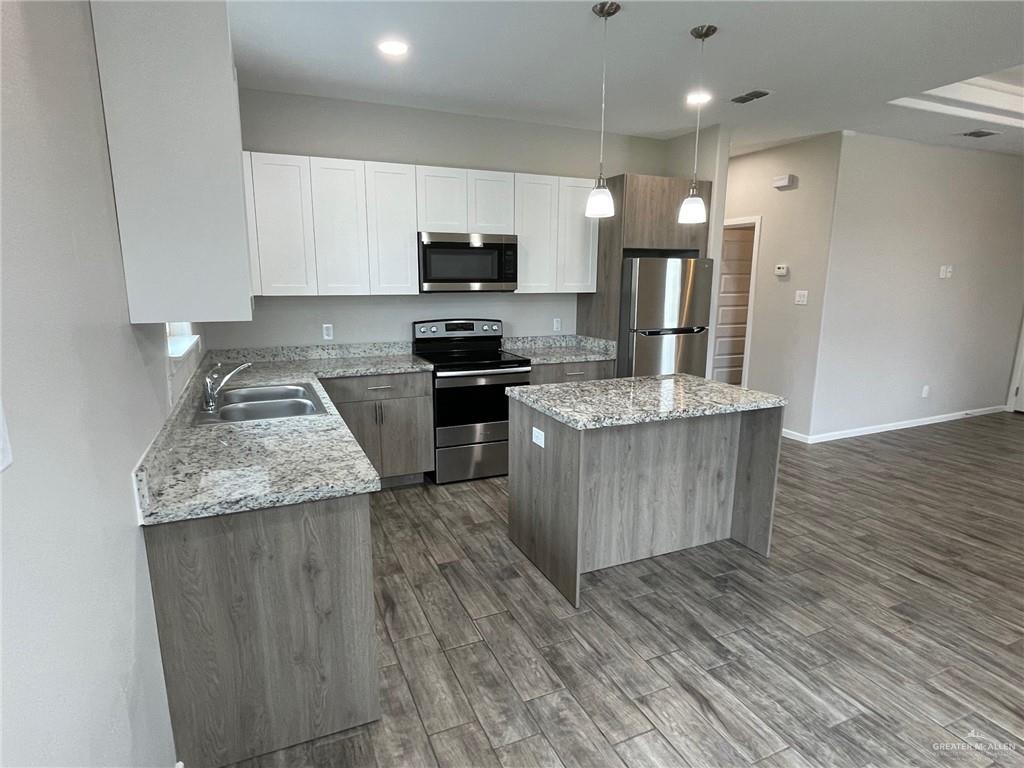 912-3 Kentucky Street Alton, TX 78573 - Photo 6 of 17 a kitchen with stainless steel appliances granite countertop a stove a sink and a refrigerator