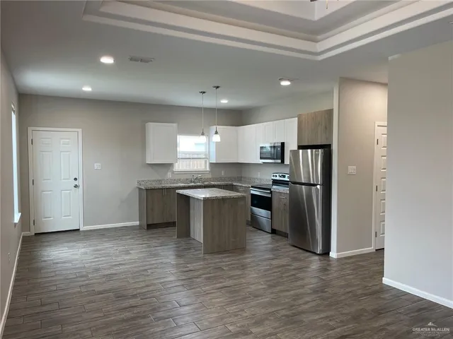 a kitchen with a refrigerator and white cabinets