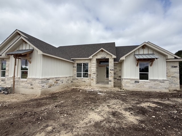 127 Riparian Elms Road Bertram, TX 78605 - Photo 2 of 22 A newly constructed residence combines white board and batten siding with elegant stone accents, ready for landscaping.