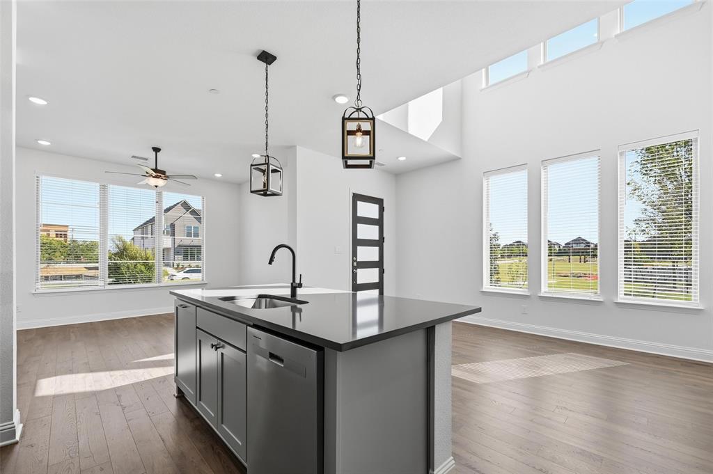 2533 Brunswick Way, Unit 2533 Allen, TX 75013 - Photo 6 of 24 a kitchen with stainless steel appliances granite countertop a sink a stove and a wooden floor