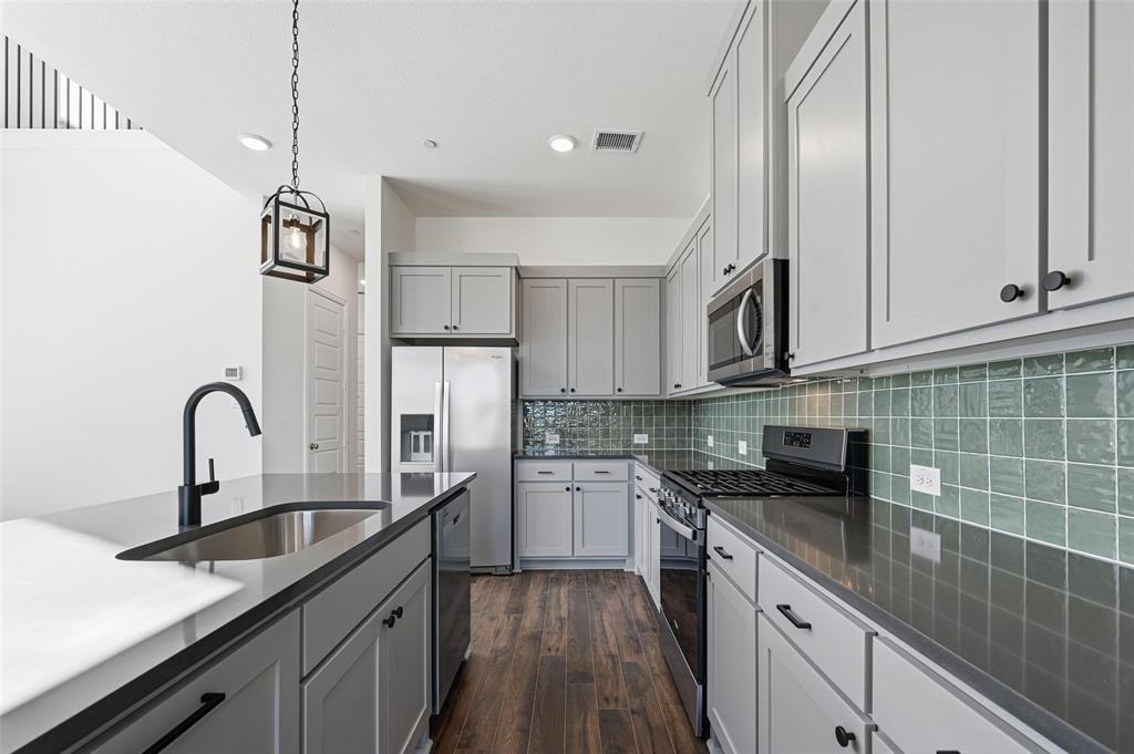 2533 Brunswick Way, Unit 2533 Allen, TX 75013 - Photo 7 of 24 a kitchen with kitchen island granite countertop a sink stainless steel appliances and cabinets