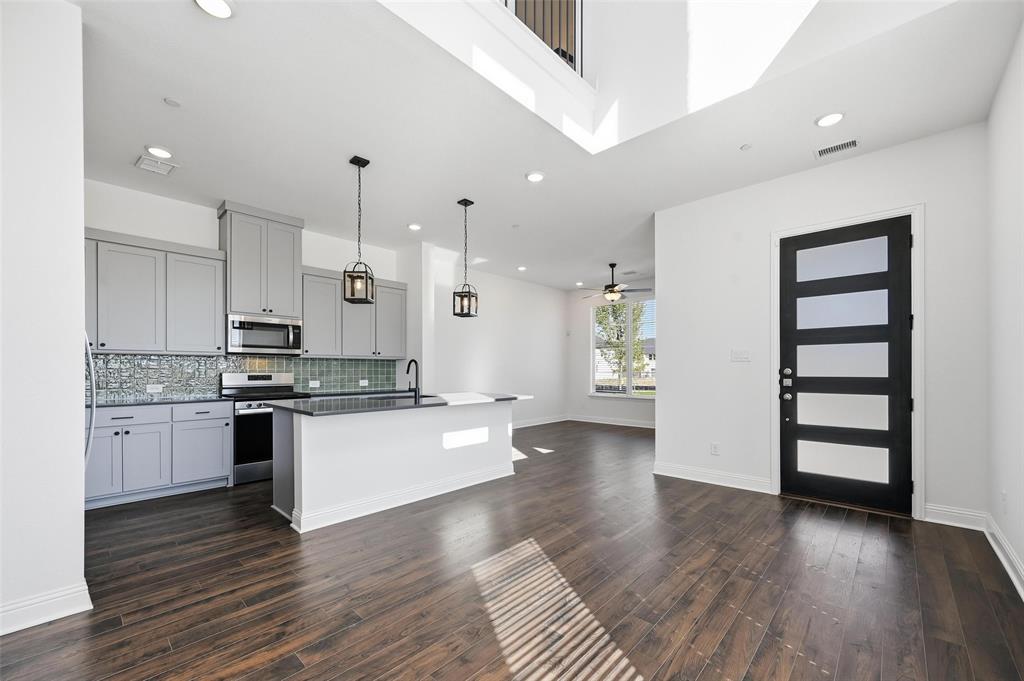 2533 Brunswick Way, Unit 2533 Allen, TX 75013 - Photo 24 of 24 a large kitchen with granite countertop a stove top oven a sink and white cabinets with wooden floor