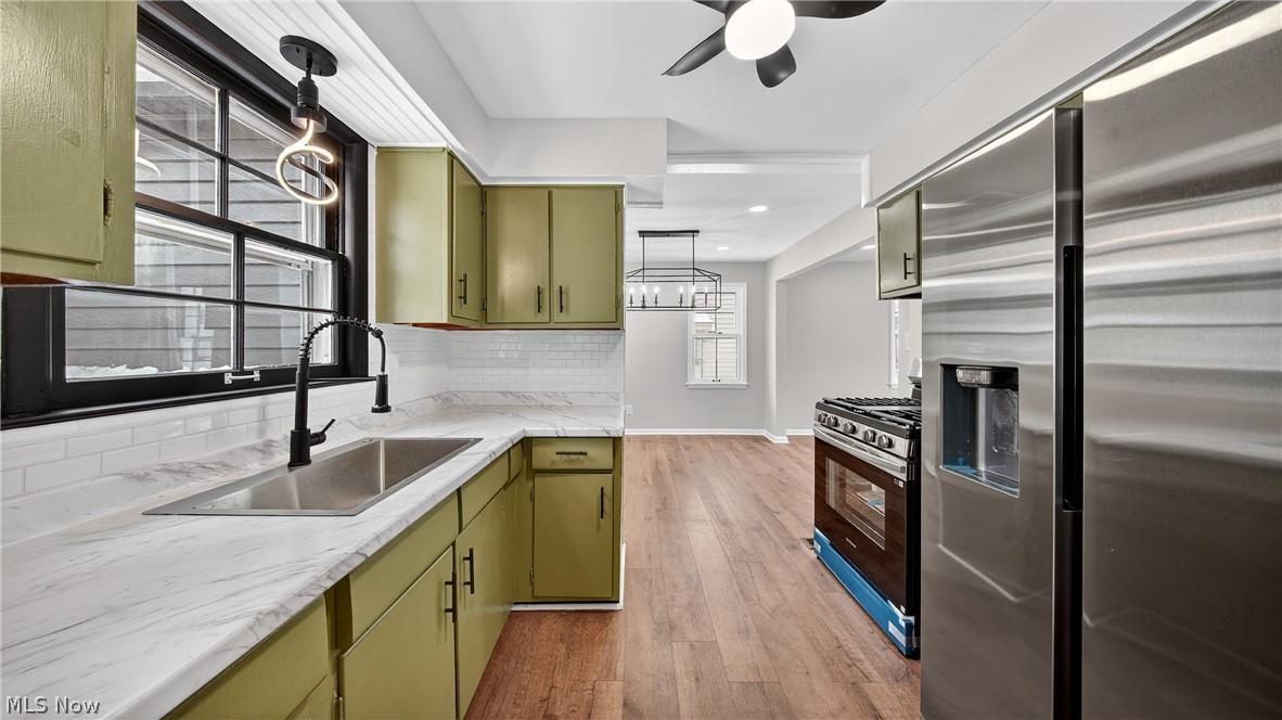 16811 Invermere Avenue Cleveland, OH 44128 - Photo 6 of 47 Kitchen featuring green cabinetry, stainless steel appliances, pendant lighting, and light wood-style flooring
