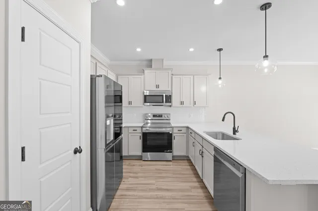 a kitchen with stainless steel appliances granite countertop a sink and a refrigerator