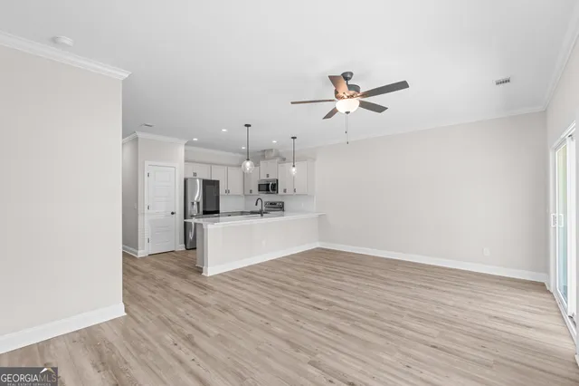 a view of a kitchen with wooden floor and a ceiling fan