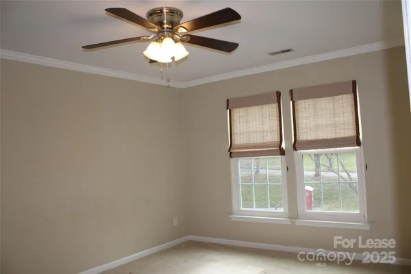 an empty room with windows and ceiling fan