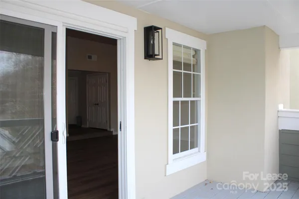 a view of a hallway with wooden floor and cabinet