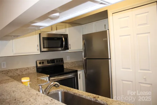 a kitchen with a refrigerator and a stove top oven