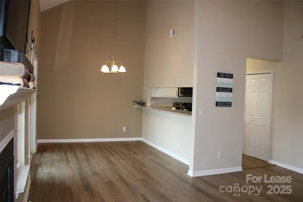 a view of a kitchen with refrigerator and wooden floor