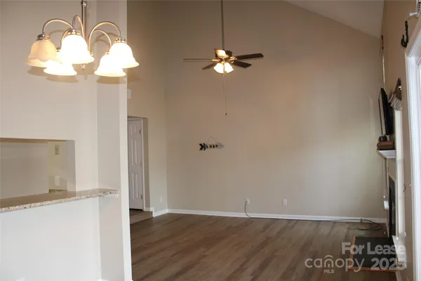 a view of a chandelier fan and wooden floor