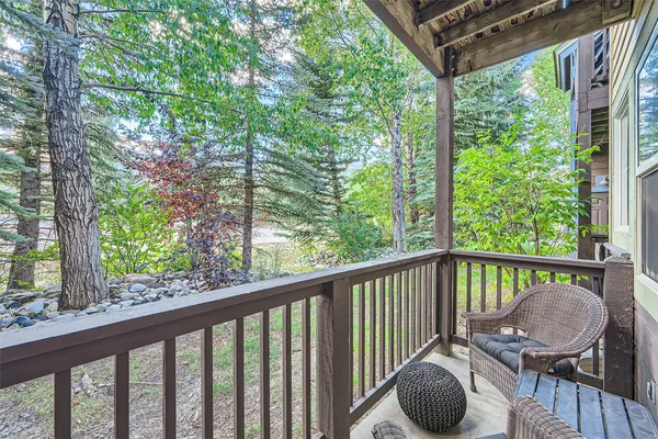a view of a balcony with chairs and wooden fence